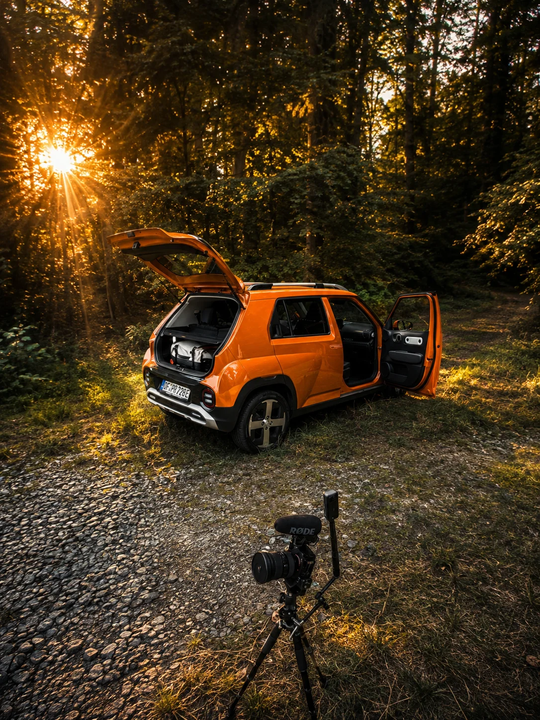 Orange INSTER with open tailgate in the forest